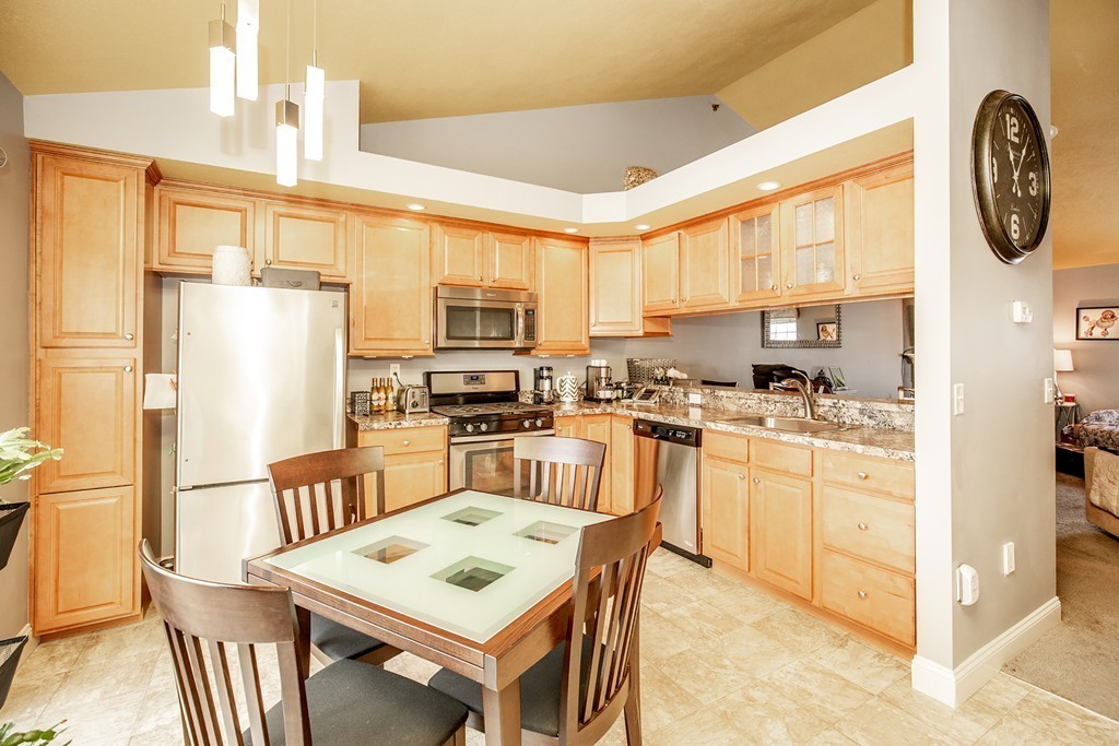 49 Hall Road, Unit 49 Fremont, NH 03044 - Photo 8 of 23 a kitchen with stainless steel appliances granite countertop a refrigerator a stove top oven a sink dishwasher and white cabinets