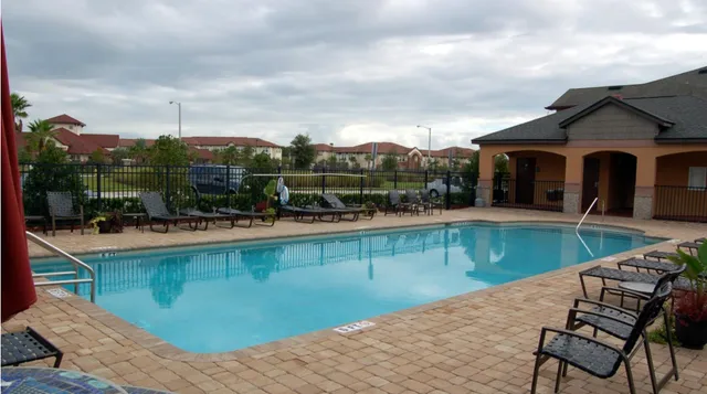 a view of a swimming pool with a patio and a yard