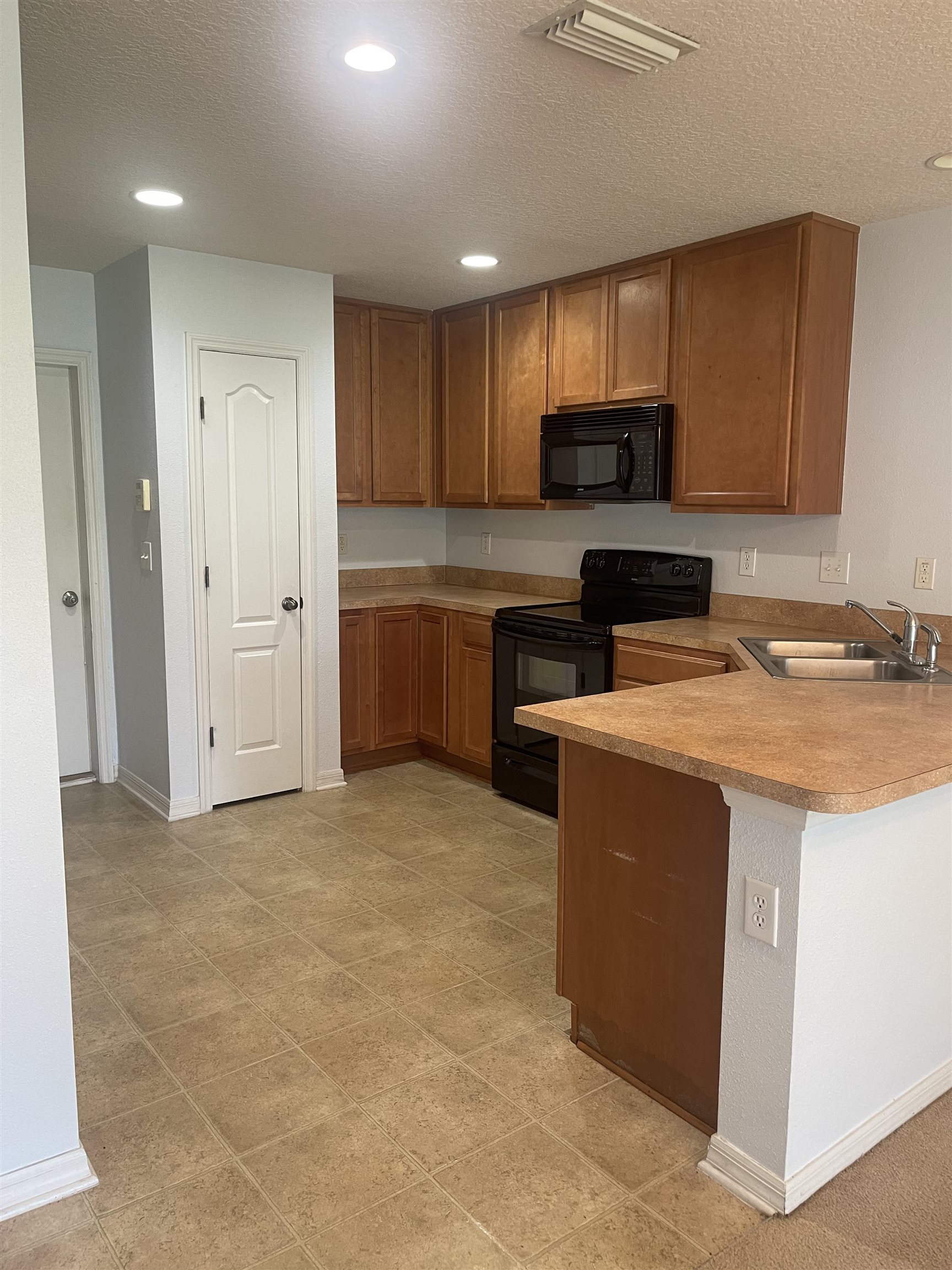 441 Cabernet Place St. Augustine, FL 32084 - Photo 5 of 16 a kitchen with stainless steel appliances granite countertop a stove top oven a sink a refrigerator and cabinets