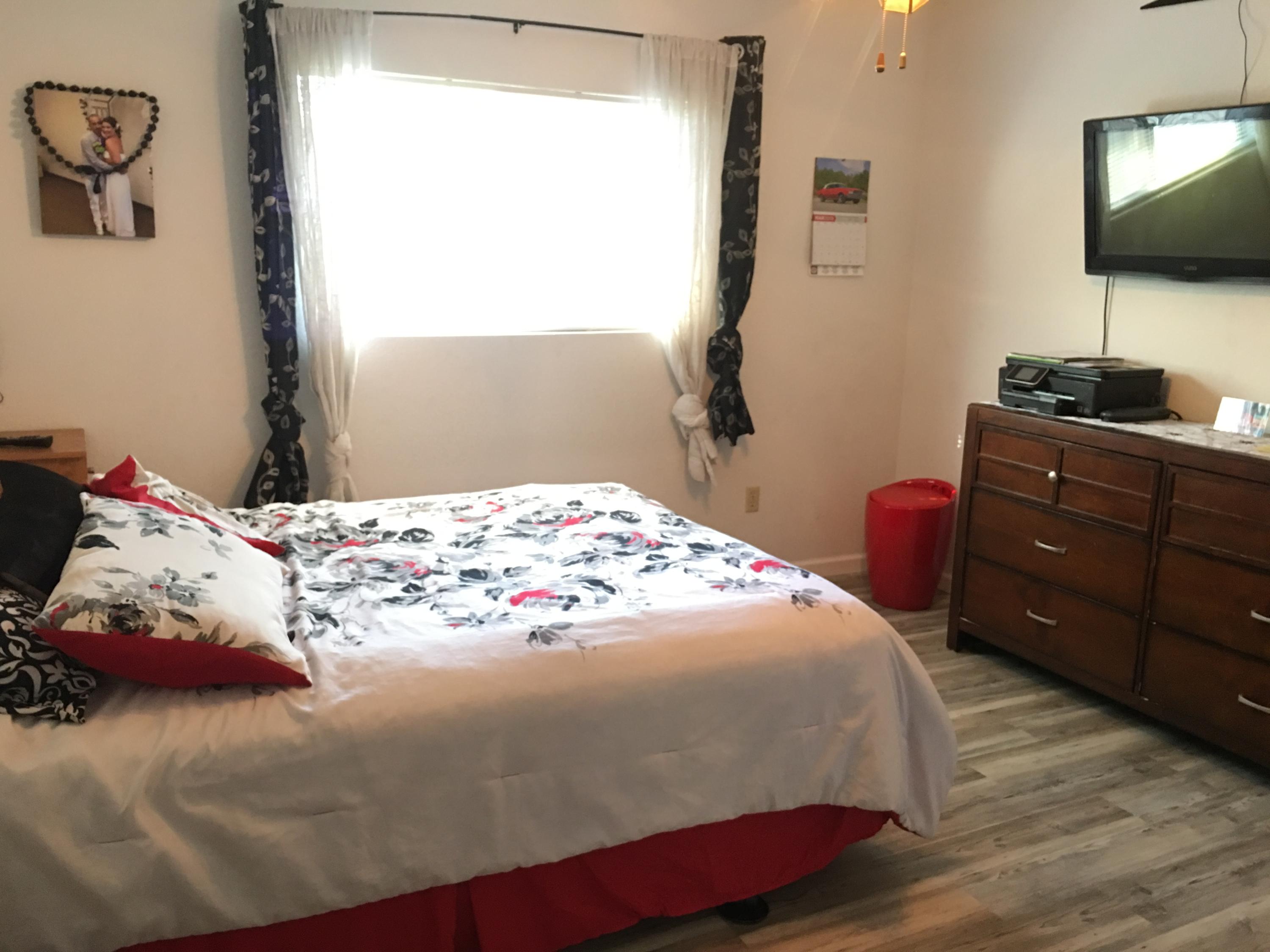 2801 Henderson Road Redding, CA 96002 - Photo 13 of 26 a bedroom with a bed and a flat tv screen on dresser
