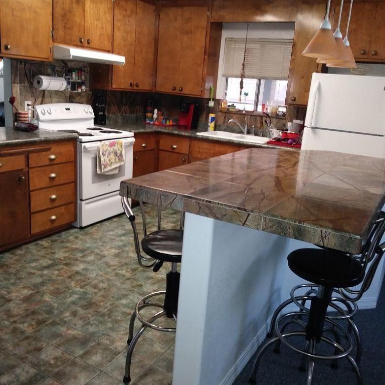 2801 Henderson Road Redding, CA 96002 - Photo 7 of 26 a kitchen with a sink a stove and chairs
