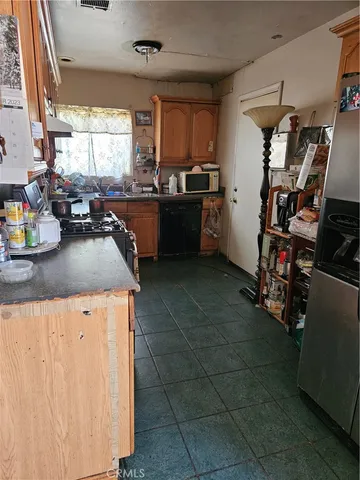a kitchen with granite countertop a sink a counter top space appliances and cabinets