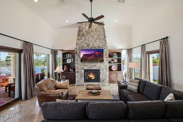 a living room with furniture fireplace and a large window