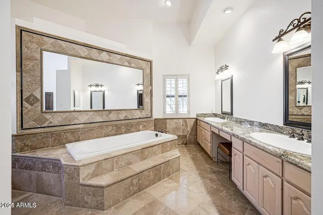 a large bathroom with a tub sink and mirror