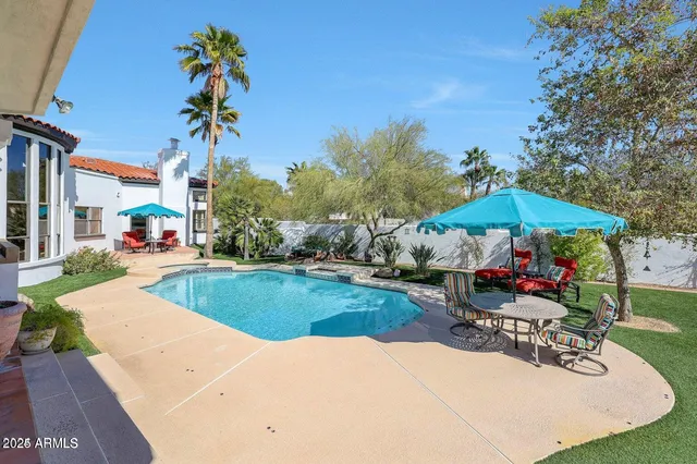 a view of a patio with a table and chairs under an umbrella