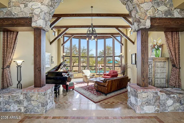 a living room with furniture a piano and a chandelier