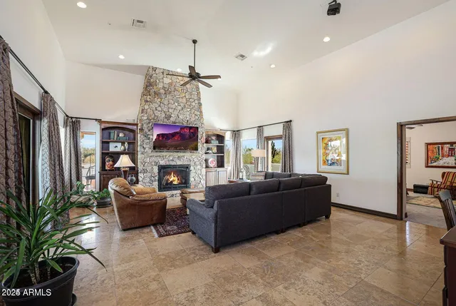 a living room with furniture a fireplace and a large window