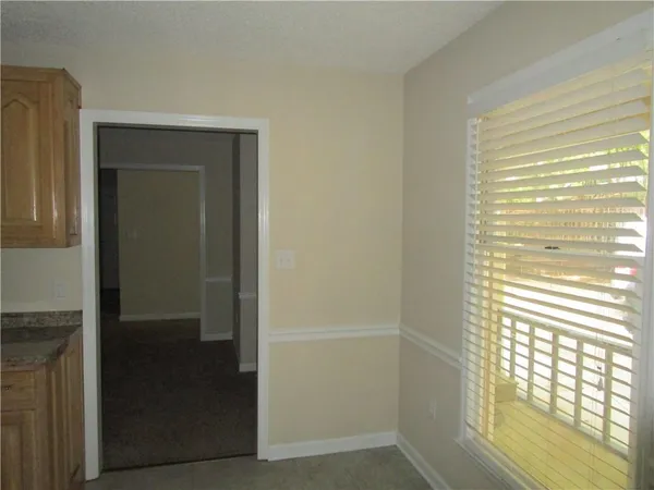 a view of an empty room with a fireplace and a window