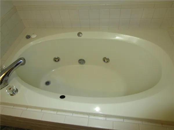 an empty room with wooden floor and ceiling fan