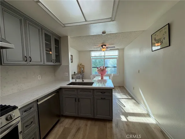 a kitchen with a sink cabinets and wooden floor