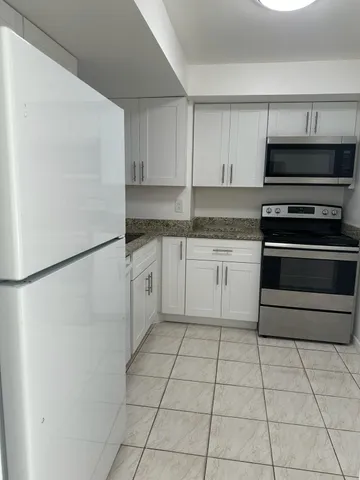 a kitchen with granite countertop white cabinets sink and dishwasher