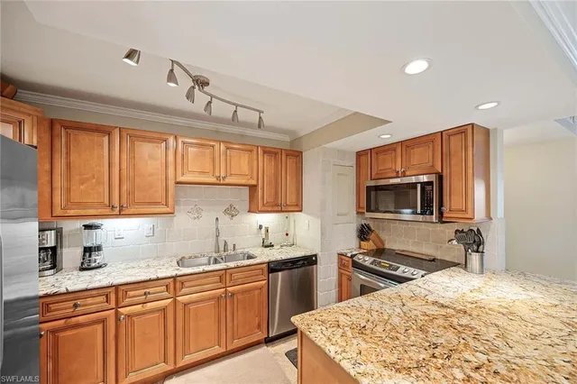 a kitchen with stainless steel appliances wooden cabinets a sink and a stove