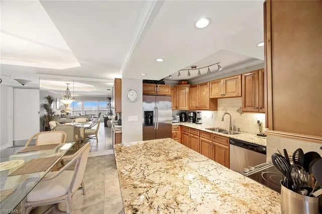 a room with stainless steel appliances kitchen island granite countertop a sink and cabinets