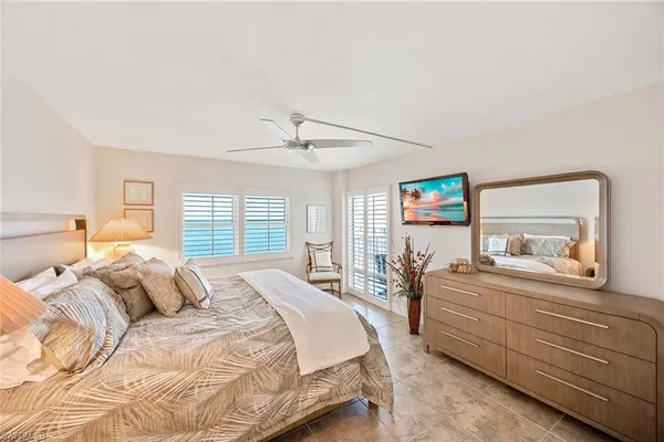 a bedroom with a bed and a large mirror with a dresser