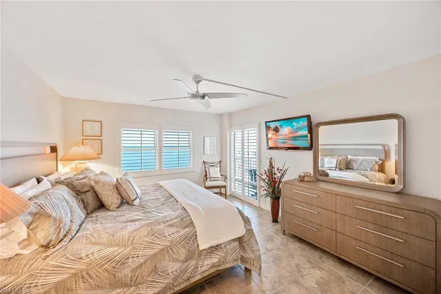 a bedroom with a bed and a large mirror with a dresser