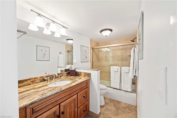 a spacious bathroom with a granite countertop sink a mirror and a shower