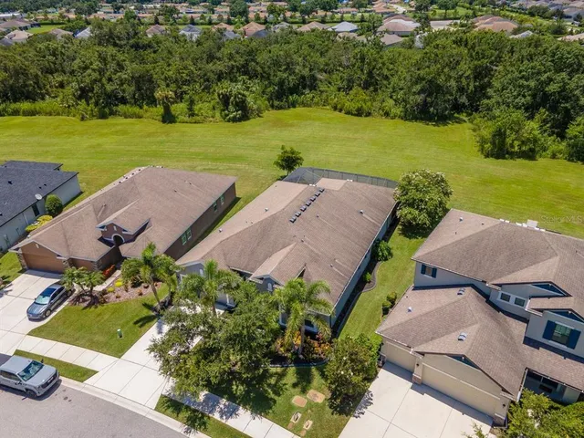 an aerial view of a house with a yard and a large pool