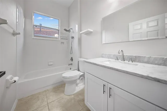 a bathroom with a granite countertop sink a toilet and shower
