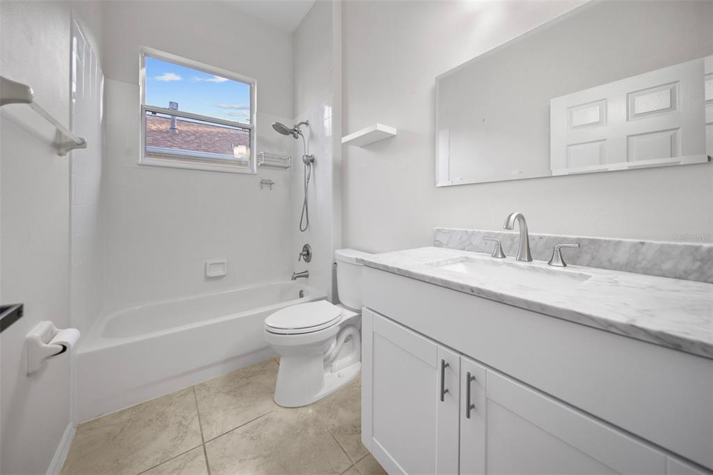2217 Caledonian Street Clermont, FL 34711 - Photo 12 of 23 a bathroom with a granite countertop sink a toilet and shower