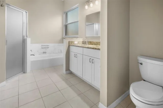a bathroom with a granite countertop toilet a sink and bathtub