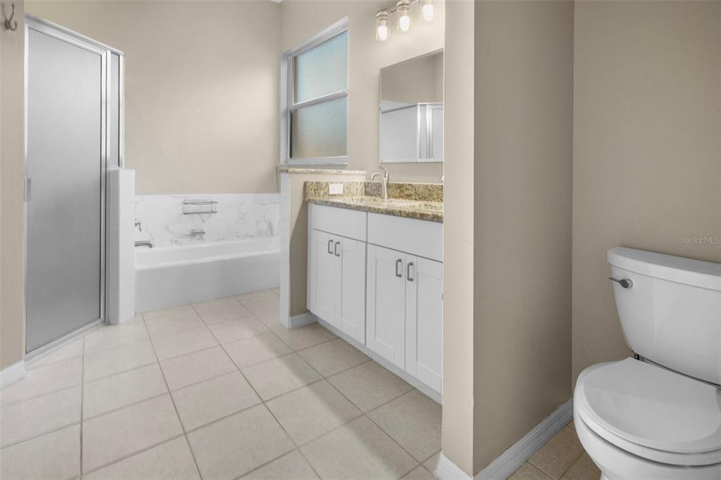 2217 Caledonian Street Clermont, FL 34711 - Photo 16 of 23 a bathroom with a granite countertop toilet a sink and bathtub