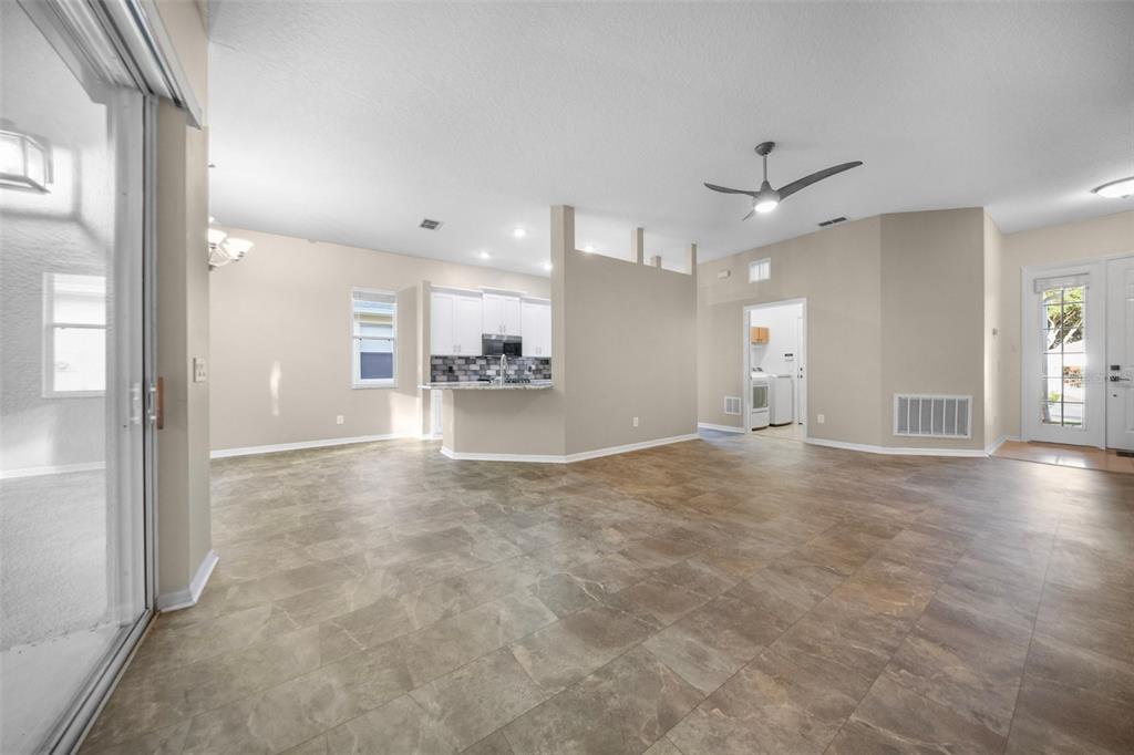 2217 Caledonian Street Clermont, FL 34711 - Photo 6 of 23 an empty room with a kitchen and windows