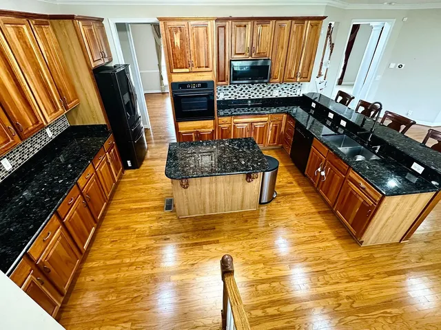 a kitchen with stainless steel appliances granite countertop a stove a sink and a microwave