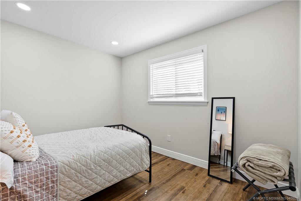 2446-2456 Southwest Hideaway Lane Stuart, FL 34994 - Photo 11 of 42 a bedroom with a bed and wooden floor