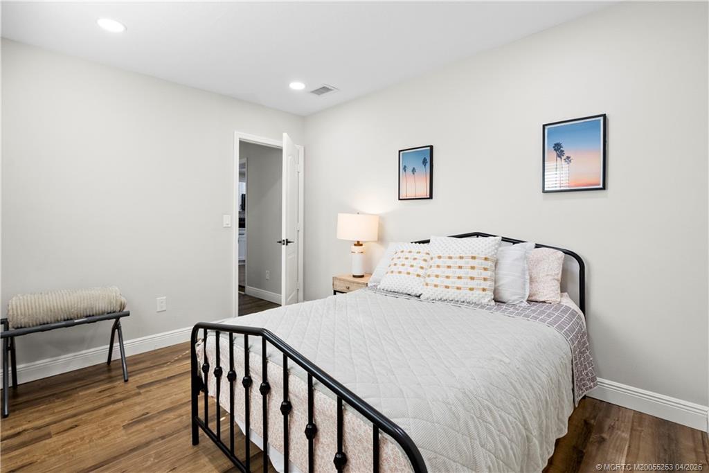 2446-2456 Southwest Hideaway Lane Stuart, FL 34994 - Photo 12 of 42 a bedroom with a bed and a table
