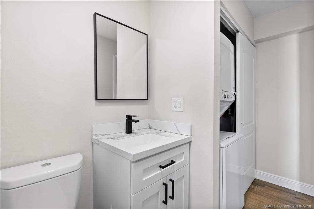 2446-2456 Southwest Hideaway Lane Stuart, FL 34994 - Photo 14 of 42 a bathroom with a toilet sink and mirror