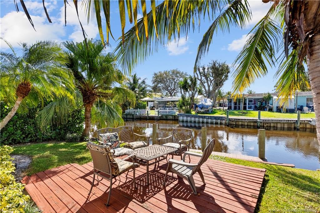 2446-2456 Southwest Hideaway Lane Stuart, FL 34994 - Photo 20 of 42 a view of a lake with a table and chairs