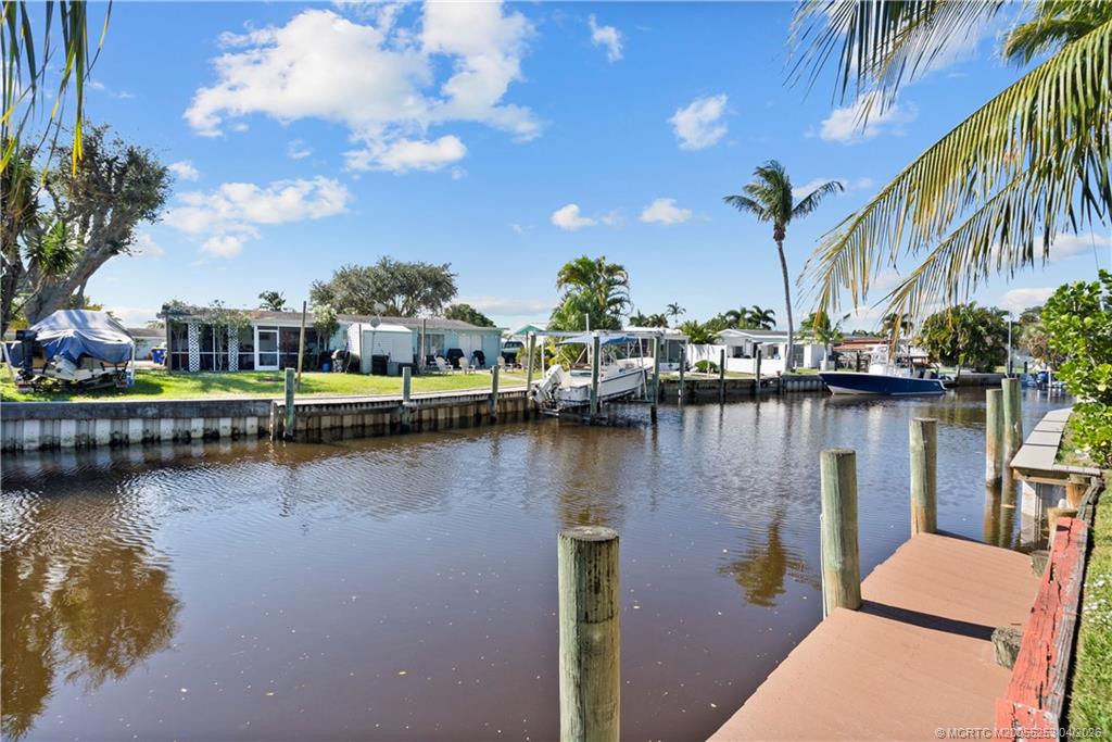 2446-2456 Southwest Hideaway Lane Stuart, FL 34994 - Photo 22 of 42 a view of a lake with a house