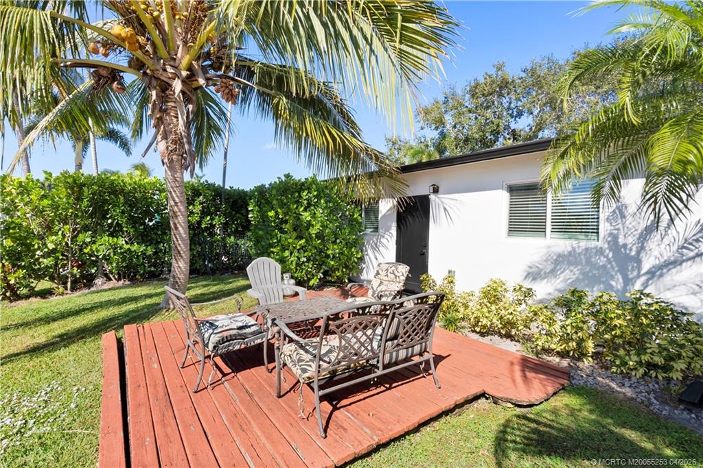 2446-2456 Southwest Hideaway Lane Stuart, FL 34994 - Photo 23 of 42 a view of a backyard with chairs potted plants and large tree
