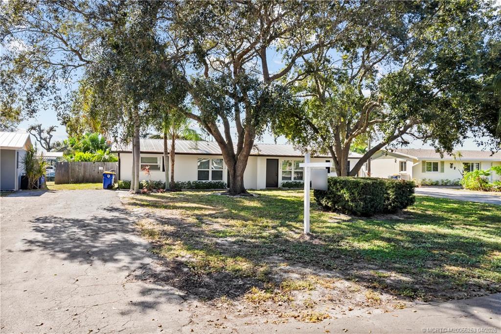 2446-2456 Southwest Hideaway Lane Stuart, FL 34994 - Photo 34 of 42 a view of a house with a yard covered in the forest