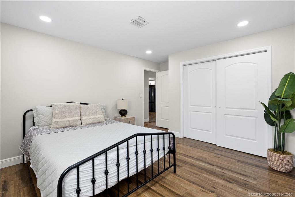 2446-2456 Southwest Hideaway Lane Stuart, FL 34994 - Photo 5 of 42 a bedroom with a bed and a potted plant
