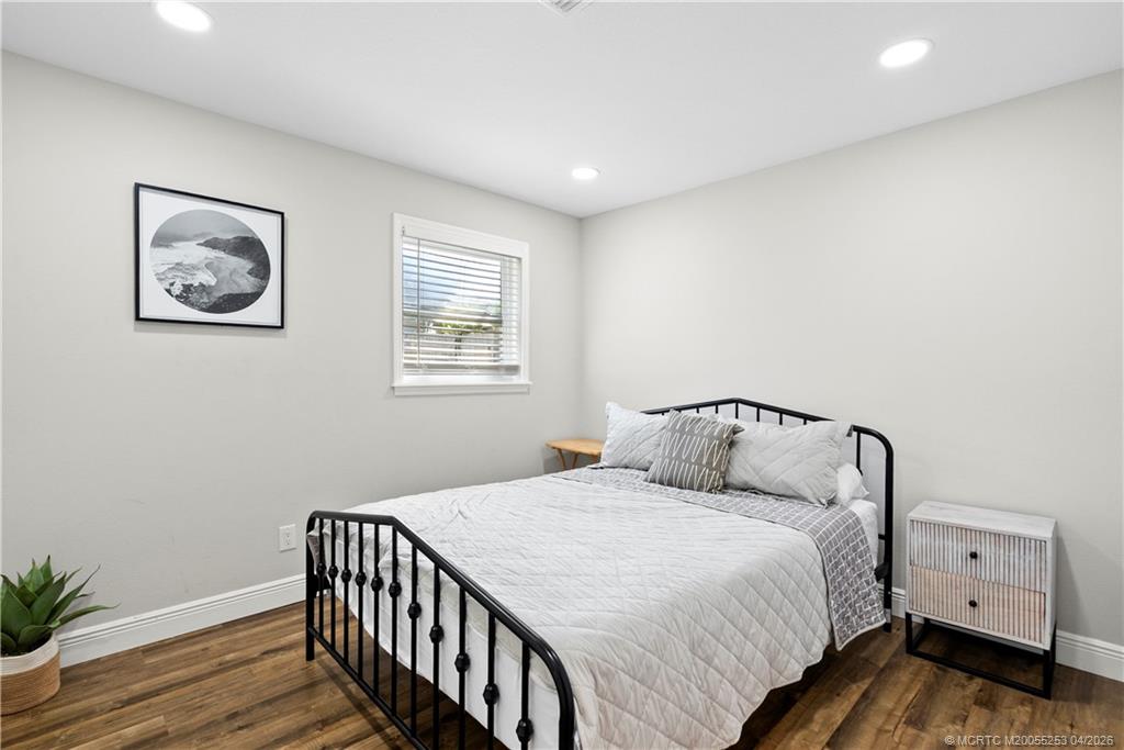 2446-2456 Southwest Hideaway Lane Stuart, FL 34994 - Photo 6 of 42 a bedroom with a bed and wooden floor