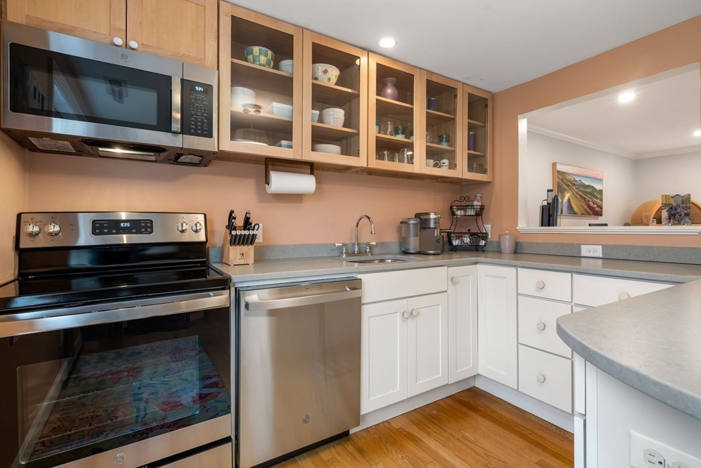 55 Jericho Road, Unit 55 Weston, MA 02493 - Photo 7 of 24 a kitchen with stainless steel appliances granite countertop a stove microwave and cabinets