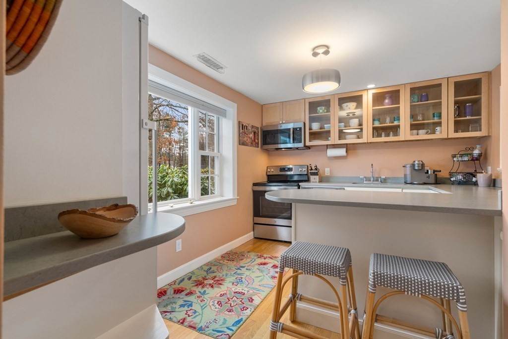 55 Jericho Road, Unit 55 Weston, MA 02493 - Photo 9 of 24 a kitchen with a table chairs stove and cabinets