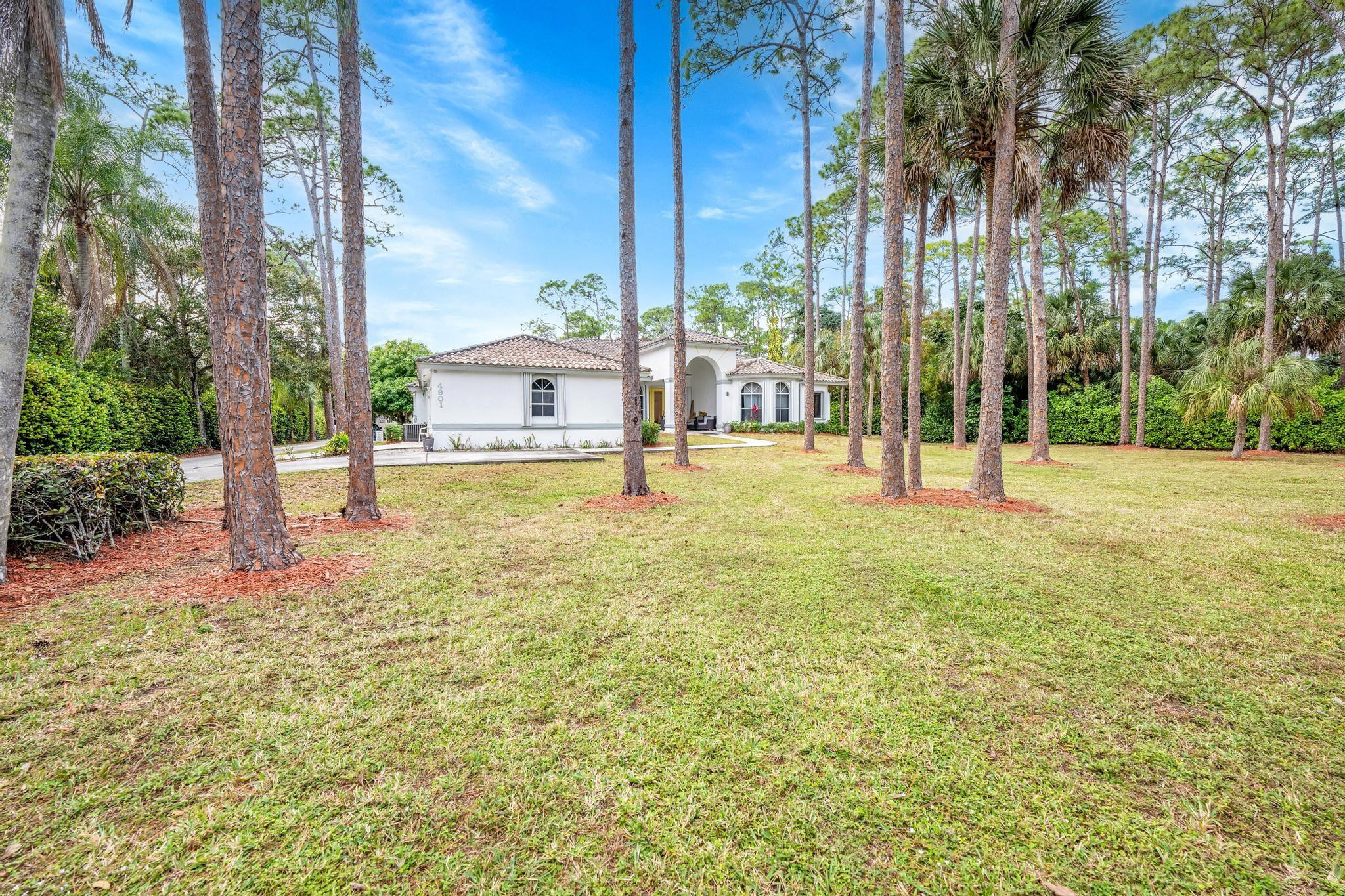 4901 Godfrey Road Parkland, FL 33067 - Photo 25 of 60 a backyard of a house with lots of green space and fountain