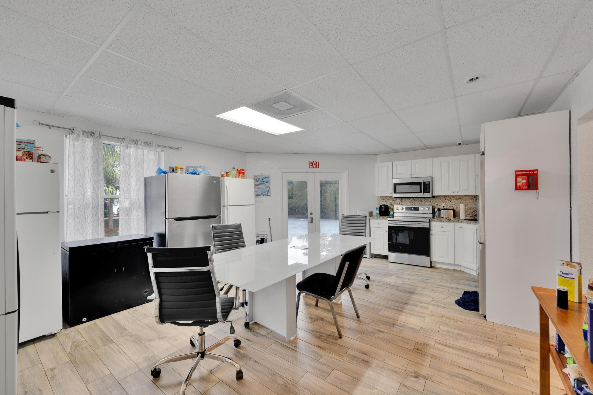 4901 Godfrey Road Parkland, FL 33067 - Photo 53 of 60 a kitchen with stainless steel appliances kitchen island granite countertop a sink a stove a refrigerator cabinets and dining table