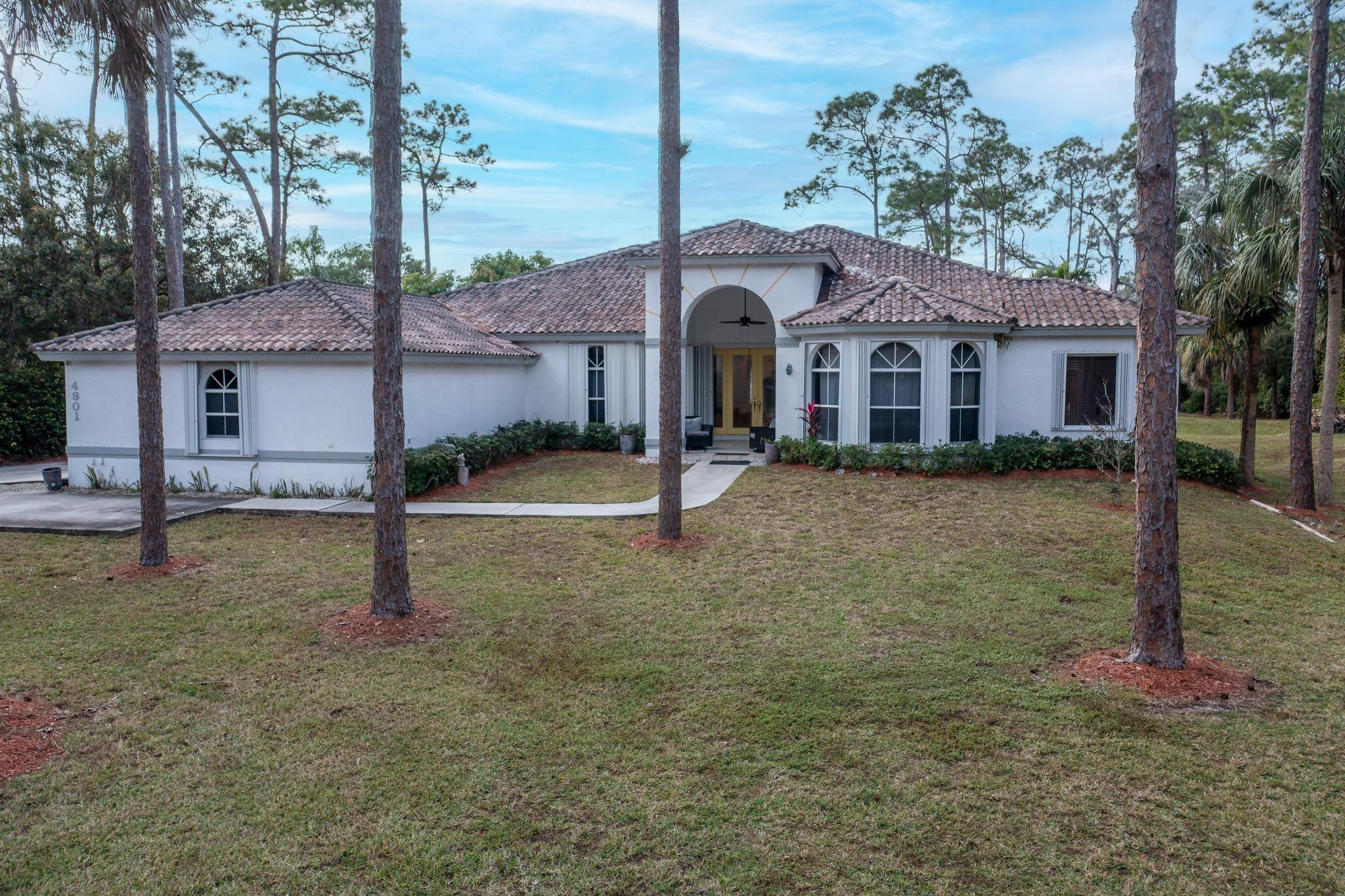 4901 Godfrey Road Parkland, FL 33067 - Photo 6 of 60 a view of a big house with a yard and large tree