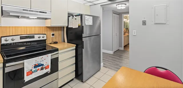 a kitchen with stainless steel appliances granite countertop a refrigerator and a stove