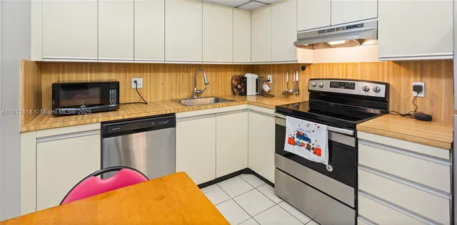 a kitchen with granite countertop a sink stainless steel appliances and cabinets