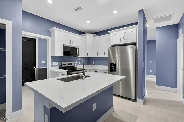 a kitchen with a refrigerator a stove top oven a sink and dishwasher