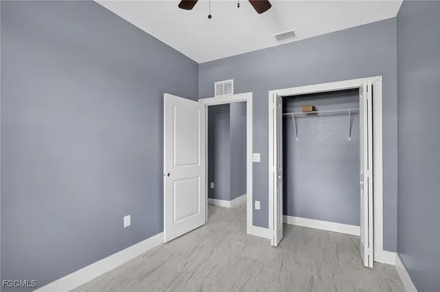 a view of an empty room with wooden floor and closet