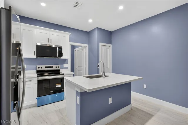 a kitchen with stainless steel appliances granite countertop a stove a sink and a refrigerator