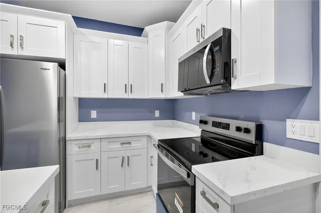 a kitchen with white cabinets and stainless steel appliances