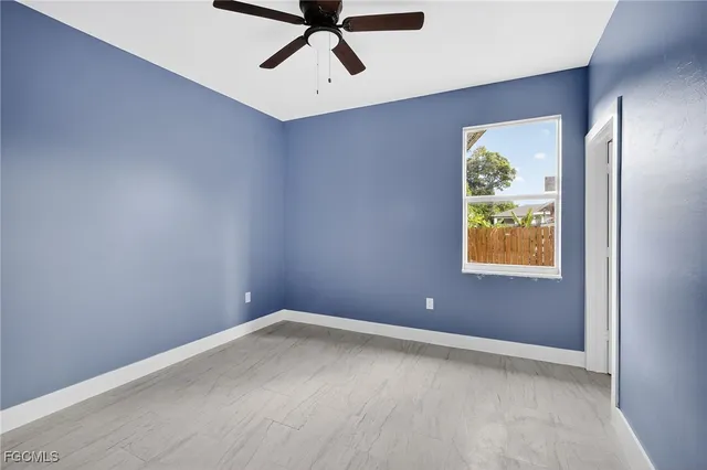 an empty room with windows and fan