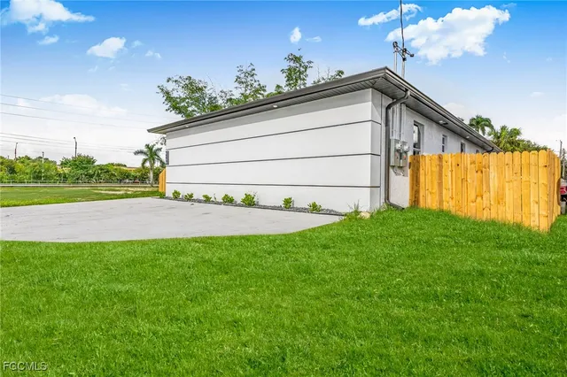 a view of a house with a big yard and potted plants