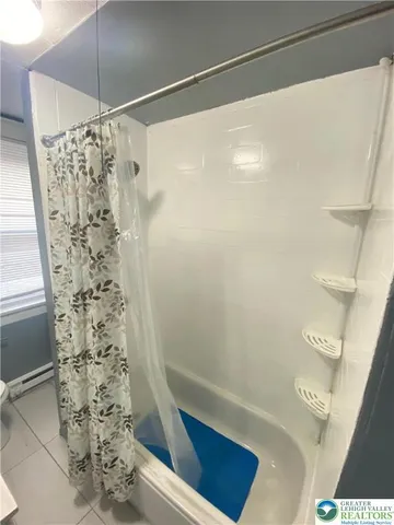 a bathroom with a sink a toilet a mirror and shower